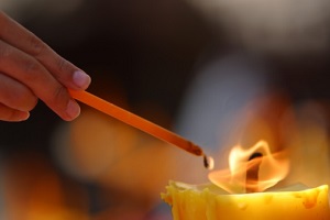 Hand lighting candle with long match