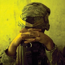 Soldier with head on clasped hands