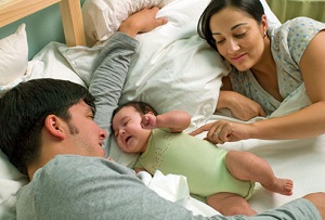 Couple lying in bed with newborn