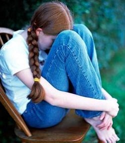 Girl hiding her face in her legs