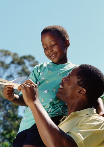 Father and son playing with paper airplane