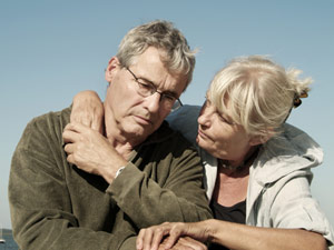 Worried woman with arm around sad man