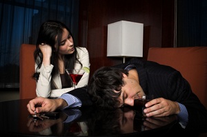 Man passed out with alcohol with woman watching