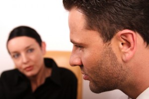 Thinking man with expectant woman in background