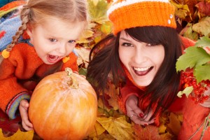 Mother and daughter with pumpkin and fall leaves