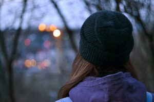 Woman looking out over city skyline on a winter evening