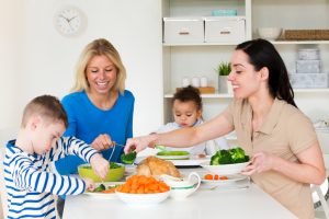 Couple sitting at dinner table with two children