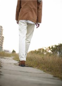 Person walking down overgrown sidewalk