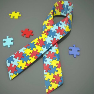 A ribbon made out of colored puzzle pieces sits on a desk with a few extra pieces laying around it.
