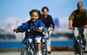 Boy riding bike with parents