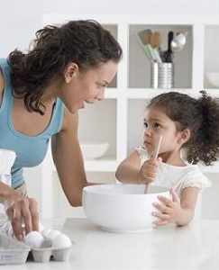 Mother and young daughter cooking