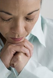Woman resting chin on clasped hands