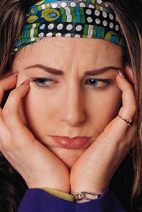 Headshot of unhappy woman resting chin on hands