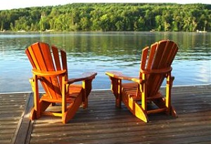 Two wooden chairs on lake dock