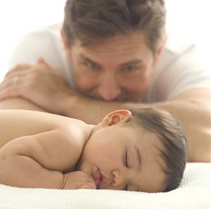 Father watching sleeping infant
