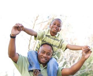 Happy boy riding on father's shoulders