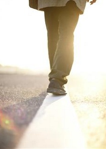 Feet walking a white line on the pavement