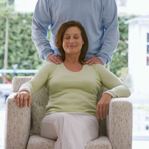 A woman smiles as her husband rubs her shoulders.