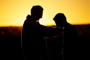 Silhouette of two men talking