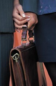 Close up of business people holding hands and brief case