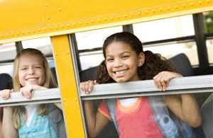 Kids peaking out bus windows
