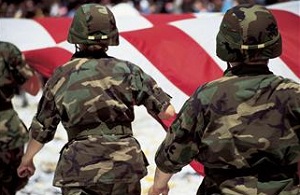 Soldiers walking away with flag in background