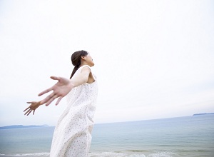 Woman on beach with outstretched arms