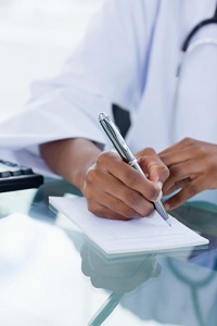 Doctor writing on notepad