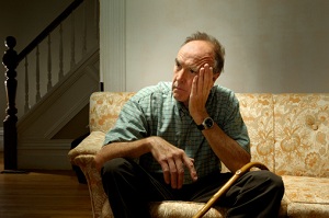 Unhappy senior man sitting on couch