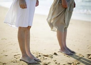 Legs of two people on beach