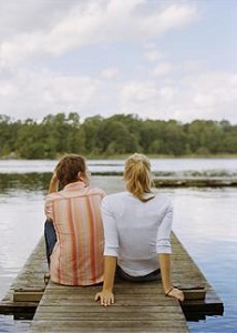 Couple sitting on lake dock