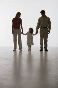 Parents holding young daughter's hands