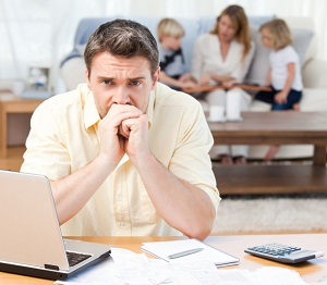 Thinking man with family in background