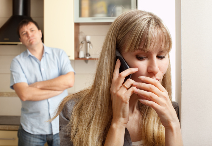 A woman conceals her phone call from her spouse