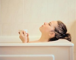 Woman in bath with tea