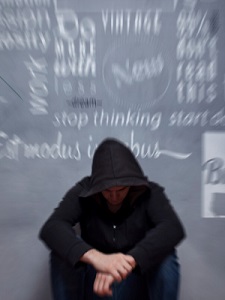 young-man-sits-near-blurry-chalkboard