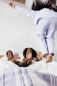 Child jumping on parent's bed