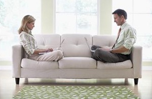 Couple on couch with laptops