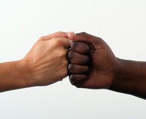 Racially different hands bumping fists