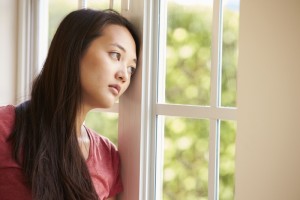Thoughtful Asian Woman Looking Out Of Window