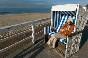 Woman sitting on bench near beach