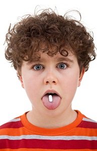 Child with pill on his tongue