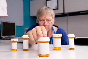 Doctor sliding pill bottle across counter