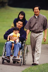 Man in wheelchair holding young boy