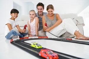 Family playing with electric race car track
