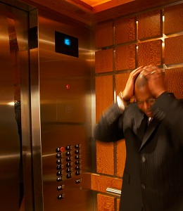 Scared man holding head in elevator