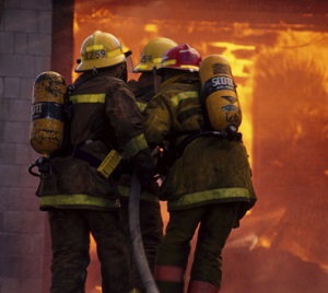 Two firefighters entering a burning house