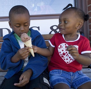 Young kids sharing ice cream cone