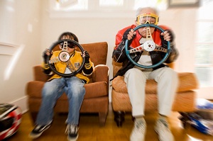 Boy and grandfather pretending to drive racecars