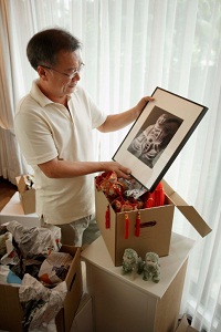 Man unpacking moving box full of Buddhist items